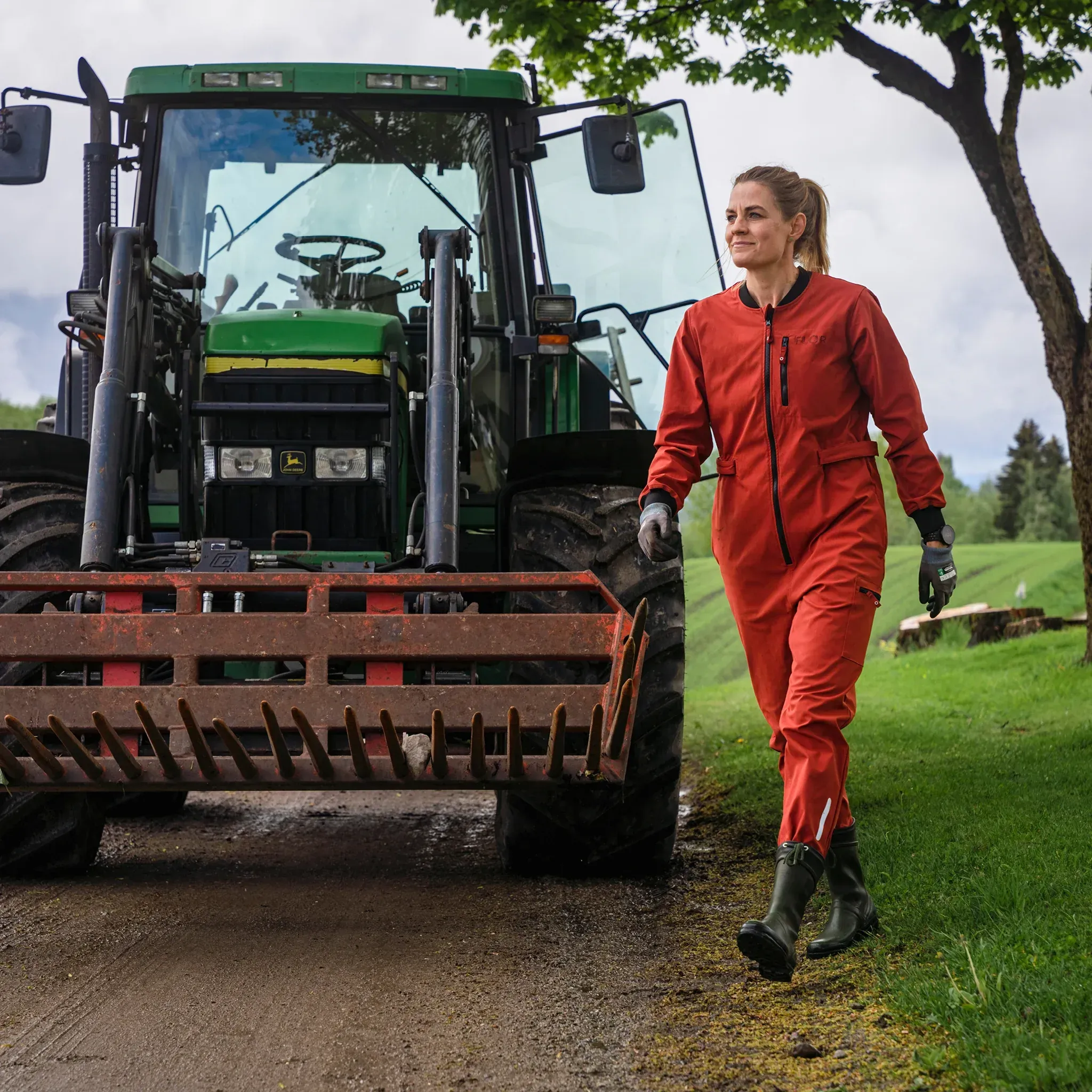 Kvinne som går forran en traktor